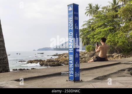 Tsunami-Gefahrenzone. Warnschild, Beschilderung der Fluchtwege im Falle eines weiteren Seebebens. Strandbereich und Küstenstraße in der Stadt Patong, K Stockfoto