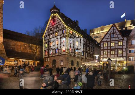 Pilatushaus, 1489 erbaut, ein historisches Stadthaus mit Adventskalender am 18. Dezember 2024 bei Dämmerung, das Kaiserschloss auf der rechten Seite, Tiergaertnert Stockfoto