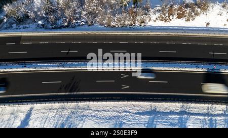 Überkopfansicht von Fahrzeugen, die im Winter auf einer verschneiten Autobahn fahren Stockfoto