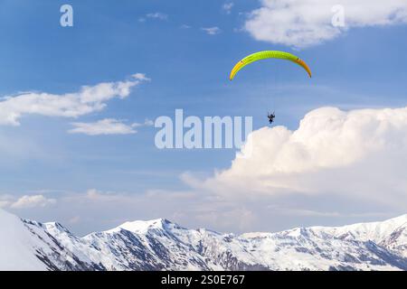 Berglandschaft mit Gleitschirmfliegern, die tagsüber über über verschneite Gipfel des Kaukasus fliegen. Gudauri, Georgien Stockfoto