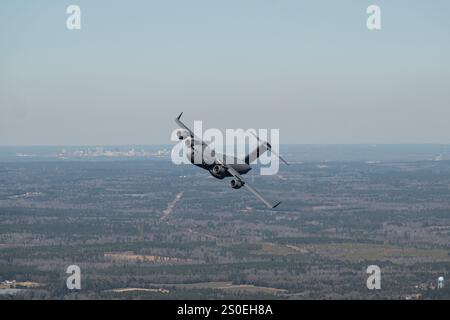 Ein C-17 Globemaster III Flugzeug, das dem 437th Airlift Wing zugeordnet ist, fliegt am 17. Januar 2024 über dem North Auxiliary Airfield in South Carolina. Das 437. AW führt Luftmobilität CommandÕs Global REACH-Luftbrücke durch, indem es Airmen und Flugzeuge weltweit zur Unterstützung von Notfalloperationen einsetzt, bei denen Streitkräfte, Ausrüstung und Vorräte aus dem Flugzeug und aus dem Flugzeug geliefert werden. (Foto der U.S. Air Force von Staff Sgt. Bryan Guthrie) Stockfoto