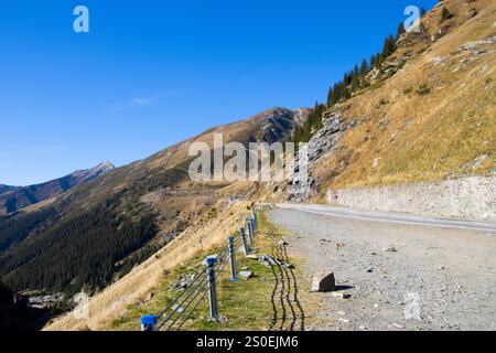 Die Straße führt durch die Fagaras Berge unter einem blauen Himmel in Arges Coubty, Roman Stockfoto