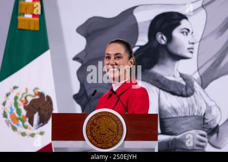 Mexiko-Stadt, Mexiko. Dezember 2024. Die mexikanische Präsidentin Claudia Sheinbaum hört eine Frage während der täglichen Pressekonferenz im Nationalpalast am 27. Dezember 2024 in Mexiko-Stadt. Sheinbaum eine neue Handy-App, um das mexikanische Konsulat für Migranten in den Vereinigten Staaten zu kontaktieren, die von der US-Einwanderungsbehörde inhaftiert werden. Quelle: Presidencia de la Republica Mexicana/Büro der mexikanischen Präsidenten/Alamy Live News Stockfoto