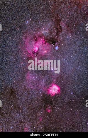 Der Rosettennebel unterhalb eines großen Nebelkomplexes bei Monoceros. Stockfoto