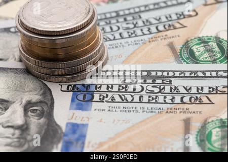 Ein Stapel Münzen und ein Schein mit den Worten Vereinigte Staaten von Amerika drauf. Die Münzen sind Silber und Gold Stockfoto