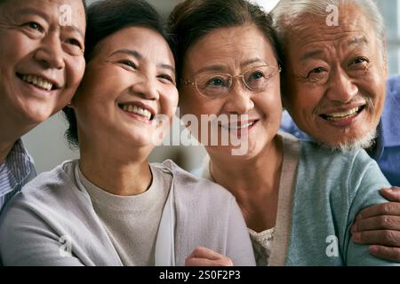 Porträt zweier glücklicher älterer asiatischer Paare, die die Kamera lächelnd betrachten Stockfoto