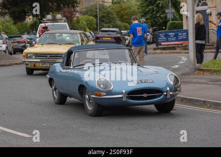 Jaguar E-Type fährt um einen Kreisverkehr Stockfoto