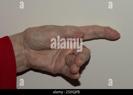 Detaillierte Ansicht der nach vorne gestreckten Hand einer älteren Frau mit Fokus auf die strukturierte Haut und die Fingernägel, die die natürlichen Zeichen des Alterns auf einem veranschaulichen Stockfoto