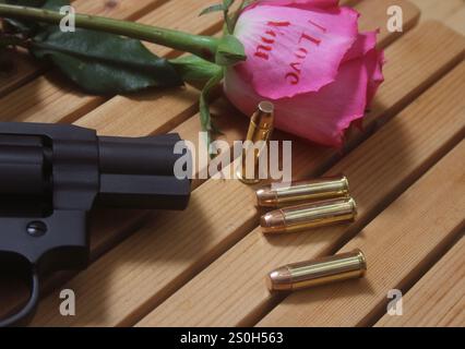 Vintage-Pistole mit Kugeln und Rose. Revolver und Ammo Stockfoto
