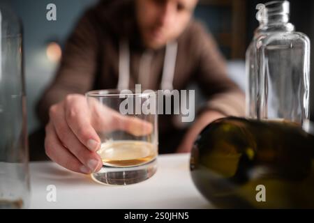 Ein betrunkener Mann, der zu Hause sitzt, hält eine Dose Alkohol in den Händen. Einsamkeit. Depressionsbekämpfung. Kopierbereich Stockfoto