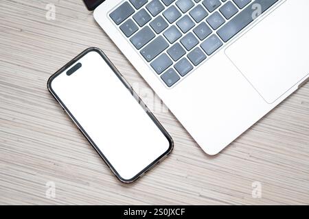 Smartphone mit White Screen Mockup neben Laptop Stockfoto