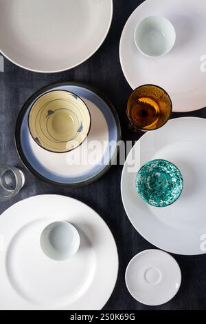 Draufsicht auf leere Teller, Schüsseln und Gläser auf schwarzem Hintergrund. Flache Lagen. Draufsicht. Lebensmittelkonzept. Stockfoto