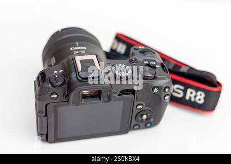 Rückansicht des neuesten Canon Kameramodells EOS R8 mit schwenkbarem LCD-Bildschirm mit EOS R8 Logo-Trageriemen auf weißem isoliertem Hintergrund Stockfoto