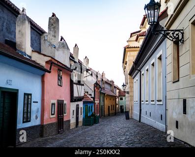 Eine malerische kopfsteingepflasterte Straße, gesäumt von farbenfrohen historischen Gebäuden, die eine Mischung aus architektonischen Stilen bieten. Die Szene ist ruhig, mit sanftem LIG Stockfoto