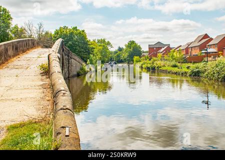 Eine alte Steinbrücke überquert den Leeds-Liverpool-Kanal an einem hellen Tag Stockfoto