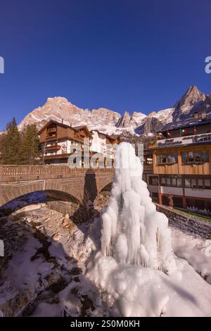 San Martino di Castrozza paese e vista sulle Pale di San Martino durante il tramonto e la fontana ghiacciata- simbolo iconico del villaggio turistico Stockfoto