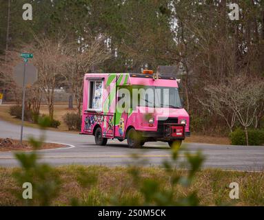 Pinkfarbener Eiswagen, der an einem Wintertag durch die Nachbarschaft fährt und Eis verkauft! Stockfoto