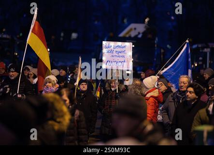 Augsburg, Deutschland. Dezember 2024. Die Teilnehmer einer Demonstration halten ein Plakat mit der Aufschrift „Wir werden nicht regiert, wir werden ruiniert!!!“. Die Kundgebung wurde vom Bürgerforum Schwaben initiiert. Laut der Ankündigung beschäftigen sich die Teilnehmer unter anderem mit sozialen Problemen, Frieden und "Deutschland zuerst". Kredit: ---/dpa/Alamy Live News Stockfoto