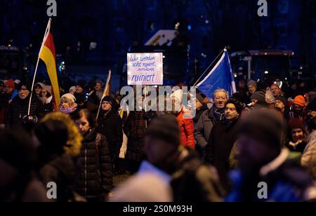 Augsburg, Deutschland. Dezember 2024. Teilnehmer einer Demonstration halten ein Plakat mit der Aufschrift ·Wir werden nicht regiert, sondern ruiniert!!· in der Hand. Initiator der Kundgebung ist das Bürgerforum Schwaben. Laute Ankündigung geht es den Teilnehmern unter anderem um soziale Probleme, Frieden und ·Deutschland zuerst·. Kredit: ---/dpa/Alamy Live News Stockfoto