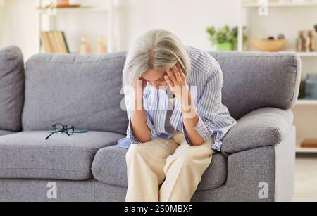 Senior traurig, alte Dame, die allein zu Hause nach unten blickt, fühlt sich ängstlich einsam, traurig depressiv Stockfoto
