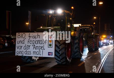 Augsburg, Deutschland. Dezember 2024. Die Teilnehmer einer Demonstration nehmen an einem marsch mit einem Traktor mit dem Slogan „Bio, frisch und regional? Vor der Ampel war es früher!" Die Kundgebung wurde vom Bürgerforum Schwaben initiiert. Laut der Ankündigung beschäftigen sich die Teilnehmer unter anderem mit sozialen Problemen, Frieden und "Deutschland zuerst". Kredit: ---/dpa/Alamy Live News Stockfoto