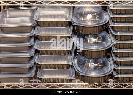 Stapelbare Lebensmittelbehälter warten auf die Verteilung in einer belebten Küche Stockfoto