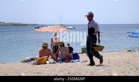 Der Kokosnussmann, der Kokosnüsse am Strand in Llafranc verkauft, im Juni 2005 Stockfoto