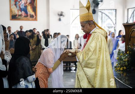 Erzbischof John Moolachira hält ein Idol des Jesuskindes, während die Gläubigen das Idol während einer Weihnachtspredigt am 25. Dezember 2024 in Guwahati küssen Stockfoto