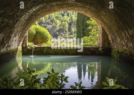 Ruhiger, gewölbter Tunnel mit Blick auf Wasser und Bäume im Hintergrund, Jardines de Alfabia Gärten, Bunyola, Mallorca, Spanien, Europa Stockfoto