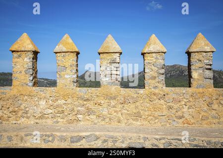 Eine Reihe von Steinmauern auf einer Burgmauer, Berge im Hintergrund, Kloster mit Burgkomplex Santuari de Sant Salvador, Arta, Mallorca, Spanien Stockfoto