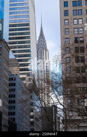 Das im Art déco-Stil aussehende Chrysler-Gebäude ist von Bürogebäuden entlang der 42nd Street in Midtown Manhattan eingerahmt. Stockfoto