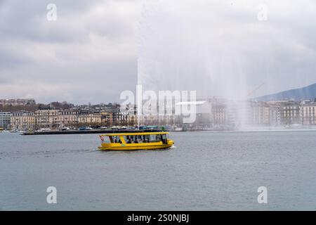 Genf, Schweiz - 10. Dezember 2024: Im Winter fährt das Touristenboot am berühmten Wasserstrahl auf dem Genfer See Stockfoto