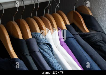 Nahaufnahme von vielen verschiedenen männlichen Hemden an Kleiderbügeln, Kleiderschrank zu Hause Stockfoto