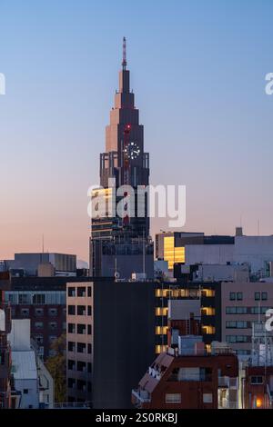 Tokio, Japan - 15. Dezember 2024 - Blick auf das NTT Docomo Yoyogi-Gebäude während des frühen Sonnenaufgangs vor klarem blauem Himmel Stockfoto