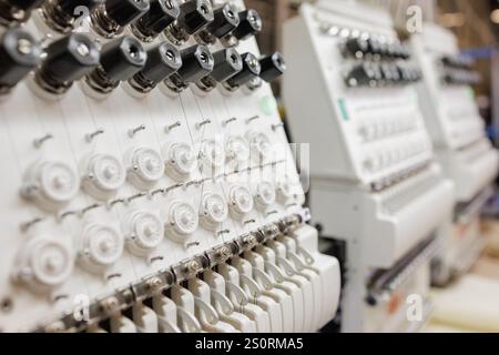 Industrieller Webstuhl in einer Webfabrik, Stickmaschine, Stickerei auf Stoff auftragen. Stockfoto