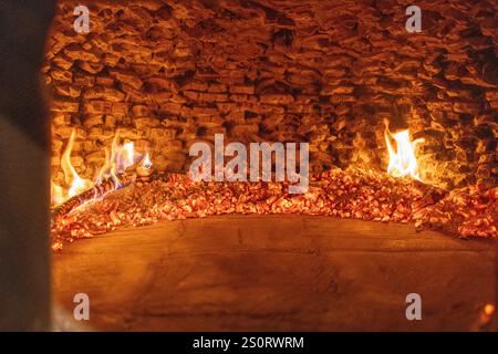 Glühende Gluten und Flammen in einem traditionellen Holzofen Stockfoto