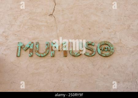 Verwitterte und rostige MUMUSO Ladenschilder, die an einer traditionellen strukturierten Wand im Al Seef Heritage District, Dubai, Vereinigte Arabische Emirate, montiert sind. Stockfoto