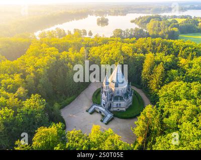 Das Schwarzenberger Grab steht majestätisch inmitten eines lebendigen grünen Waldes in Domanin, Tschechien. Die ruhige Lage unterstreicht die gotische Architektur des Grabes vor einem Hintergrund des ruhigen Wassers. Stockfoto