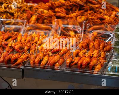 Street Food auf dem thailändischen Markt. Große gegrillte Garnelen auf Plastiktellern auf einem Nachtmarkt. Fisch Und Meeresfrüchte. Stockfoto