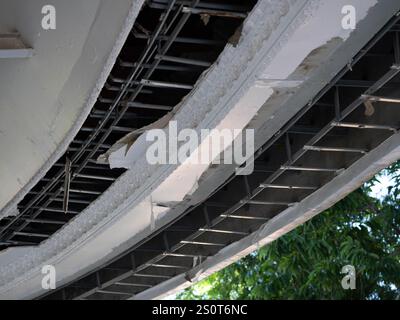 Deckenpaneele beschädigten ein großes Loch im Dach aufgrund von Regenwasser. Service- und Reparaturkonzept. Stockfoto