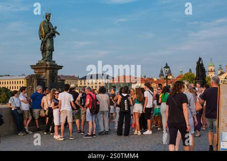 Touristen an der Skulptur des Heiligen Johannes von Nepomuk, Schutzpatron der Tschechischen Republik, Karlsbrücke, Prag, Tschechien, Tschechien. 18. Jahrhundert. Stockfoto