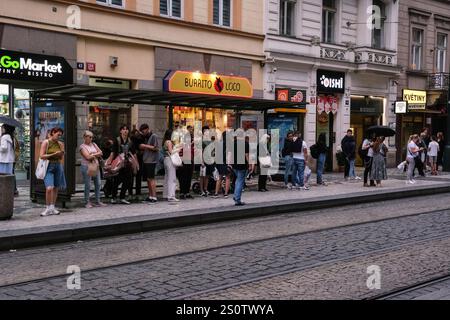 Passagiere, die an der Straßenbahnhaltestelle in Prag, Tschechien, Tschechien warten. Stockfoto