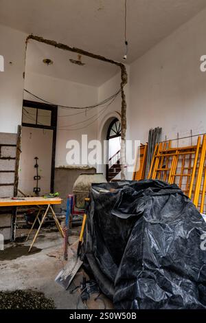 Ein Zimmer mit einer schwarzen Plastikdecke auf dem Boden. Das Zimmer wird gerade renoviert Stockfoto