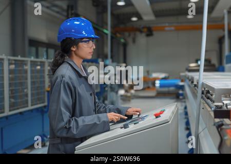 Weibliche Ingenieurin, die in der Produktionslinie arbeitet und industrielle Prozesse überwacht. Stockfoto