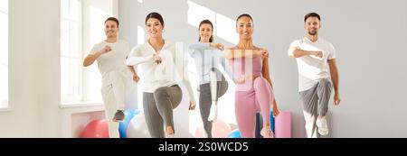 Glückliche lächelnde Athleten, die während des Trainings im Fitnessstudio Sport treiben. Stockfoto