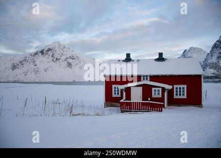 Wunderbarer Winterblick auf rot-weiße Gebäude und bewölkten Himmel. Typische Naturlandschaft der Lofoten und Vesteralen Inseln. Norwegen. Stockfoto