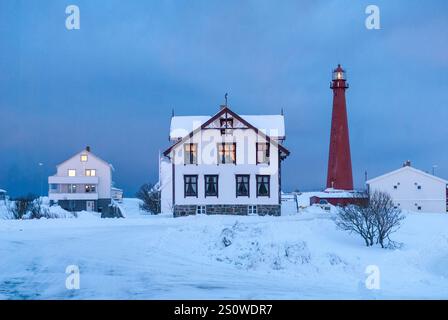 Wunderbarer Winterblick auf rot-weiße Gebäude, Leuchtturm und bewölkten Himmel. Typische Naturlandschaft der Lofoten und Vesteralen Inseln. Norwegen. Stockfoto