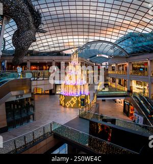 LEEDS, GROSSBRITANNIEN - 24. DEZEMBER 2024. Das Innere des Trinity Shopping Centre im Stadtzentrum von Leeds zur Weihnachtszeit mit Dekorationen und beleuchtetem CH Stockfoto