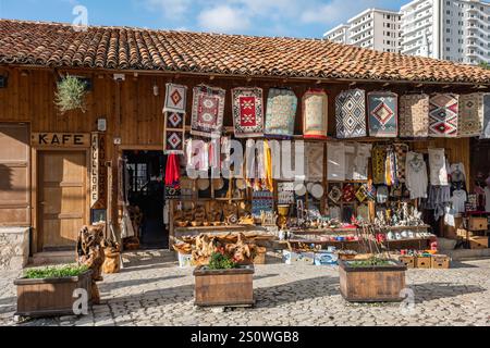 Traditioneller osmanischer Markt in Kruja. Flohmarkt. Alter Basar in Kruje Albanien mit Verkaufsständen, die handgefertigte bunte Teppiche, Souvenirs, T-Shirts und T-Shirts verkaufen Stockfoto