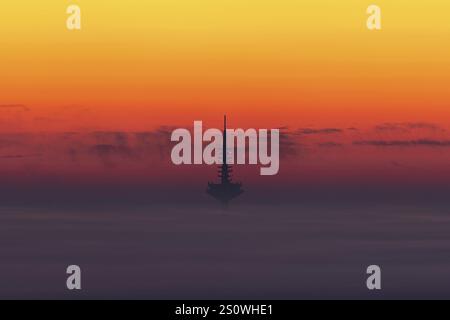 Der Europaturm in Frankfurt am Main erhebt sich bei Sonnenaufgang aus der Nebel- und Wolkendecke über dem Rhein-Main-Gebiet. Kronberg, Malerblick, Hessen, Deutschland, Stockfoto